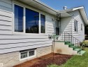 White horizontal siding exterior with multiple windows - 5530 46 Street, Barrhead, AB 