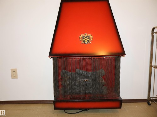 Freestanding fireplace featuring a vibrant red and black ombré finish - 5530 46 Street, Barrhead, AB 