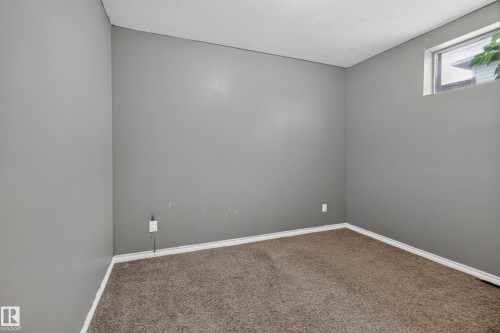 Carpeted room with a high-set window and neutral gray walls - 9315 132A Avenue, Edmonton, AB 