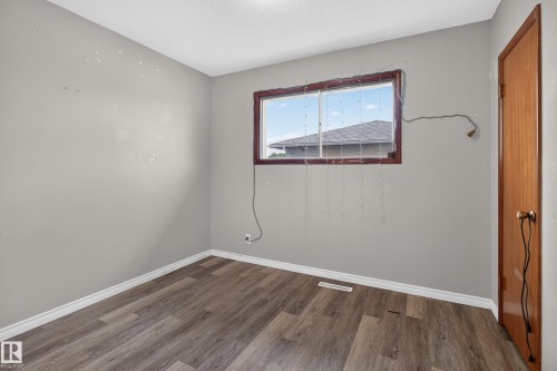 Interior room featuring wood-finish flooring, white baseboards, and light gray walls - 9315 132A Avenue, Edmonton, AB 