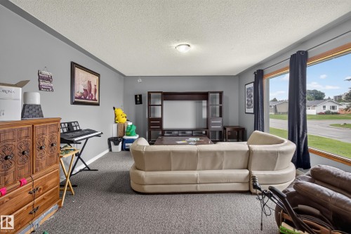 Living area featuring light gray walls and textured carpeting - 9315 132A Avenue, Edmonton, AB 