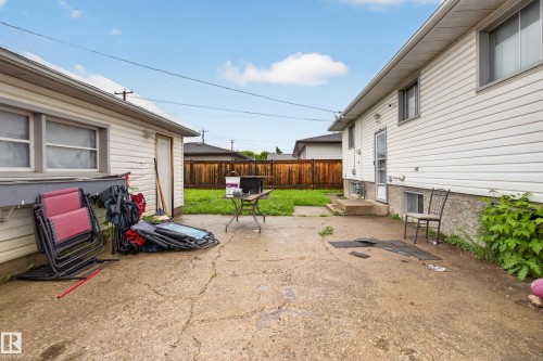 Concrete patio area with a detached garage featuring white siding, a single entry door, and a window - 9315 132A Avenue, Edmonton, AB 