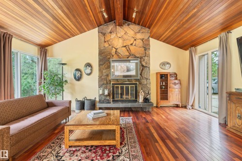Vaulted wood-paneled ceiling accentuates the stone-clad fireplace with a slate hearth - 20515 5 Avenue Sw, Edmonton, AB 