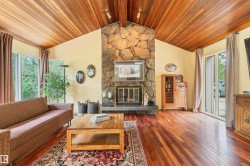 Vaulted wood-paneled ceiling accentuates the stone-clad fireplace with a slate hearth - 