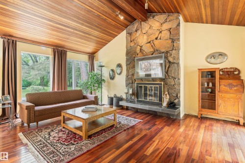 Vaulted wood-paneled ceiling accenting a stone fireplace with a tiled hearth - 20515 5 Avenue Sw, Edmonton, AB 