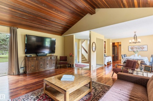 Vaulted wood-paneled ceiling accenting a spacious living area with hardwood flooring - 20515 5 Avenue Sw, Edmonton, AB 
