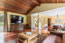 Vaulted wood-paneled ceiling accenting a spacious living area with hardwood flooring - 