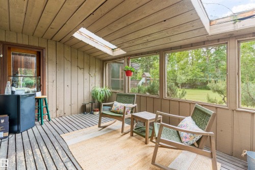 Screened porch with wood-finish flooring, wood-paneled walls, and a wood-slat ceiling - 20515 5 Avenue Sw, Edmonton, AB 