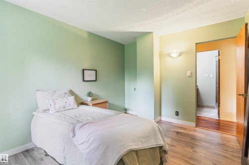 Room featuring light green wall paint and wood-finish flooring - 20515 5 Avenue Sw, Edmonton, AB 