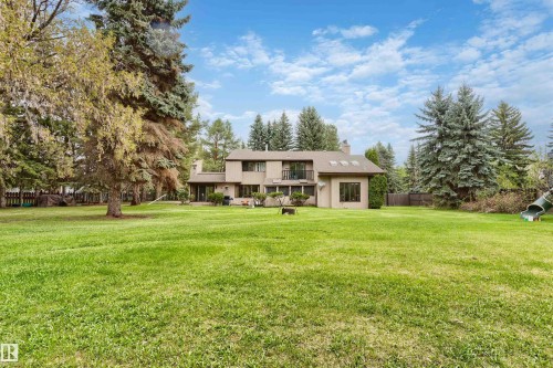 Expansive green lawn with mature evergreen and deciduous trees - 20515 5 Avenue Sw, Edmonton, AB 