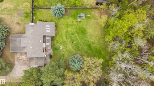 Expansive green lawn with mature trees and a paved driveway - 20515 5 Avenue Sw, Edmonton, AB 