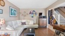 Living area with wood-finish flooring, neutral wall tones, and an arched entryway - 1827 36 Street Nw, Edmonton, AB 