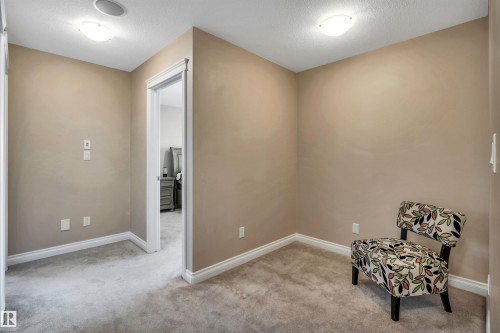Carpeted room with neutral paint, white baseboards, and a doorway opening to an additional room - 18 Voleta Crest, Spruce Grove, AB 