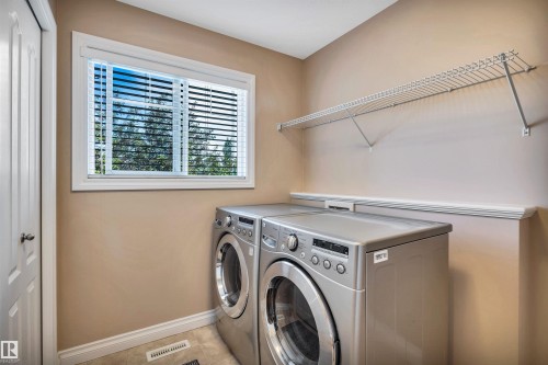 Dedicated laundry area featuring a white framed window, horizontal blinds, and a built-in wire shelf - 18 Voleta Crest, Spruce Grove, AB 