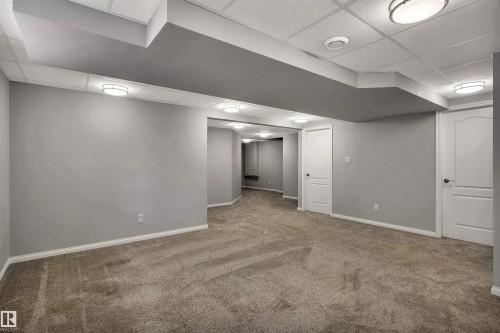 Carpeted interior space featuring light gray walls, white baseboards, and white paneled doors - 18 Voleta Crest, Spruce Grove, AB 