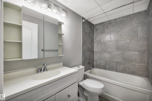 Full bathroom featuring a vanity with integrated sink, chrome faucet, and cabinet storage - 18 Voleta Crest, Spruce Grove, AB 