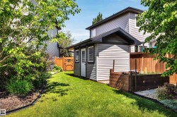 Backyard featuring a dedicated storage shed with horizontal siding and a dark trim roofline - 