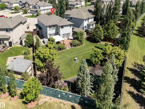 Spacious property featuring a large backyard, multi-level wood deck, established landscaping, mature trees, and a detached shed - 18 Voleta Crest, Spruce Grove, AB 