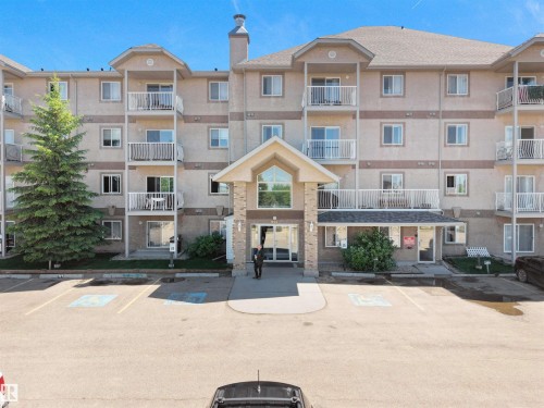 Multi-story residential building featuring a stucco exterior with decorative banding - #217 240 Spruce Ridge Rd, Spruce Grove, AB - Outdoor With Balcony With Facade