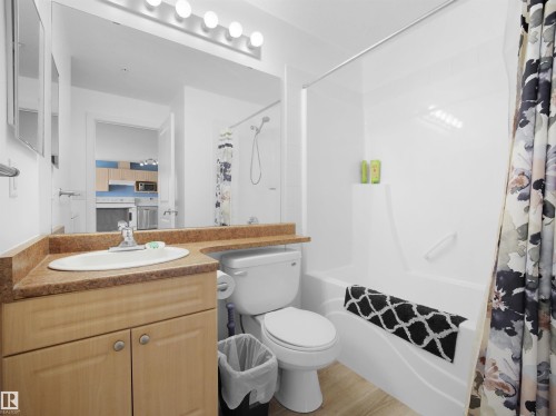 Bathroom featuring a white tub-shower combination, a vanity with wood-finish cabinetry, a single basin sink, and a brown countertop - #217 240 Spruce Ridge Rd, Spruce Grove, AB - Indoor Photo Showing Bathroom