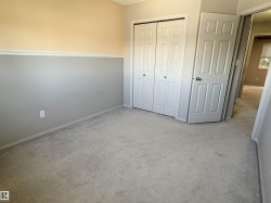 Carpeted room featuring a two-tone wall treatment with a chair rail, a bi-fold closet door, and a paneled entry door - 