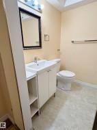 Bathroom featuring a white vanity with integrated sink, chrome faucet, and adjacent open shelving - 