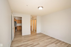 Spacious room featuring wood-finish flooring, light neutral wall tones, and a ceiling-mounted light fixture - 