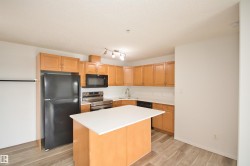 Kitchen featuring wood-finish cabinetry, white countertops, a central island, stainless steel appliances, and wood-look flooring - 