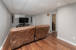 Finished room featuring wood-finish flooring, recessed lighting, drop ceiling, and light gray walls - 