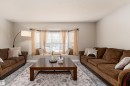 Living area featuring a bay window with an integrated window seat, wood-finish flooring, and light neutral wall colors - 10008 144 Ave, Edmonton, AB 