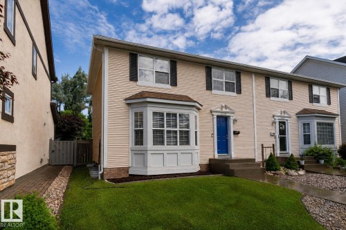 Cream-colored siding facade featuring a prominent bay window with white trim - 10008 144 Ave, Edmonton, AB 