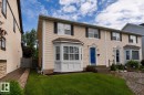 Cream-colored siding facade featuring a prominent bay window with white trim - 10008 144 Ave, Edmonton, AB 
