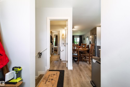 Wood-finish flooring extending from the entryway into the living and dining areas - 10811 73 Avenue, Edmonton, AB 
