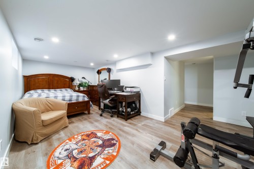 Versatile room featuring light wood-finish flooring, recessed lighting, and a neutral wall palette - 10811 73 Avenue, Edmonton, AB 