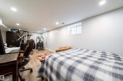 Spacious room featuring light wood-finish flooring, recessed lighting, and a white framed window - 10811 73 Avenue, Edmonton, AB 