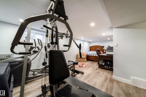 Finished lower level featuring recessed lighting, light wood-finish flooring, and white baseboards - 10811 73 Avenue, Edmonton, AB 