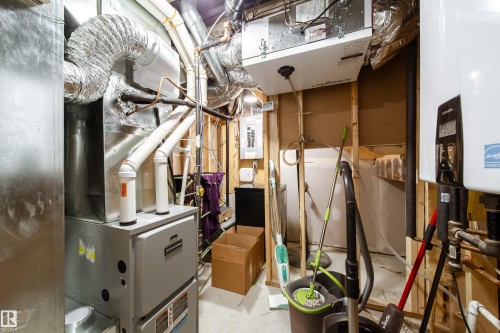 Utility space featuring a forced air furnace, water heater, and electrical panel - 10811 73 Avenue, Edmonton, AB 
