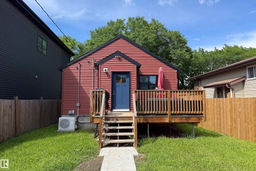 Red siding exterior with a blue entry door and black trim - 10811 73 Avenue, Edmonton, AB 