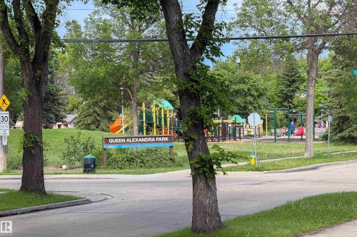 Queen Alexandra Park featuring a vibrant playground with multiple structures, expansive green spaces, and mature trees - 10811 73 Avenue, Edmonton, AB 