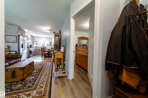 Open-concept living area with wood-finish flooring extending into the kitchen and dining areas - 10811 73 Avenue, Edmonton, AB 