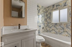 Bathroom featuring a white vanity with an integrated sink, a contemporary faucet, and a wall-mounted mirror - 