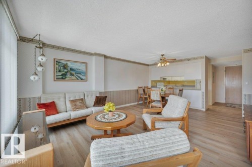 Open-concept living space featuring wood-finish flooring and a multi-light pendant fixture - 316 2011 137 Avenue, Edmonton, AB - Indoor Photo Showing Living Room