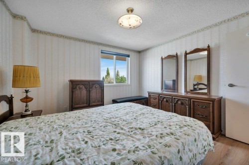 Bedroom with wood-finish flooring, a double window, and a white ceiling with a flush-mount light fixture - 316 2011 137 Avenue, Edmonton, AB - Indoor Photo Showing Bedroom