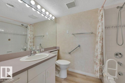 Bathroom featuring a vanity with an integrated sink, a full-width mirror, and a wall-mounted light bar - 316 2011 137 Avenue, Edmonton, AB - Indoor Photo Showing Bathroom