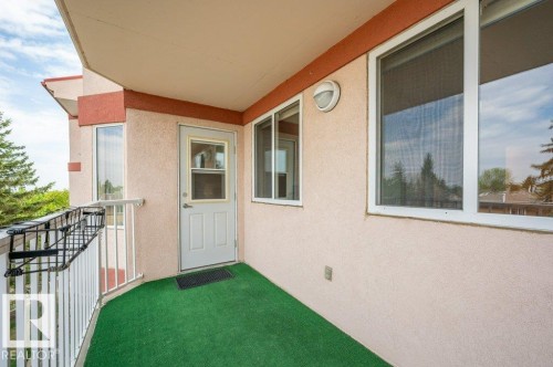 Covered balcony featuring stucco exterior, white railing, and exterior wall sconce - 316 2011 137 Avenue, Edmonton, AB - Outdoor With Balcony With Exterior