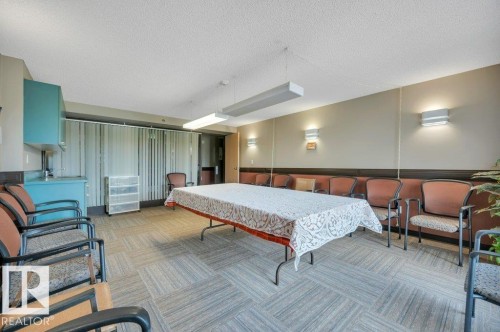 Common area featuring patterned carpet flooring and a built-in refreshment counter with a sink and storage cabinetry - 316 2011 137 Avenue, Edmonton, AB - Indoor