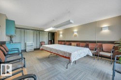 Common area featuring patterned carpet flooring and a built-in refreshment counter with a sink and storage cabinetry - 