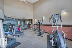 Fitness room featuring a patterned carpet, high ceilings, and recessed lighting - 