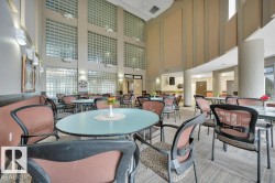 Multi-level interior space featuring extensive glass block windows, high ceilings, and a combination of recessed and wall-mounted lighting - 