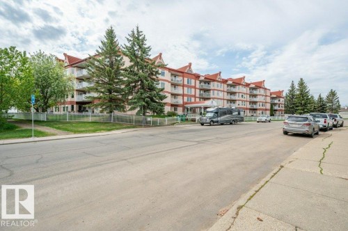 Multi-story residential building with light-toned siding and red-toned roof accents - 316 2011 137 Avenue, Edmonton, AB - Outdoor With Balcony With Facade